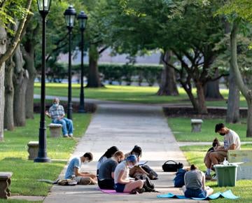 Students sitting on sidewalk