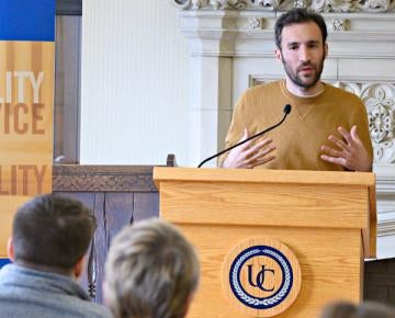 Male talking at podium at University Club