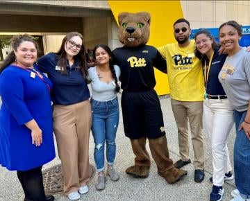 Group of students on campus with Roc the panther