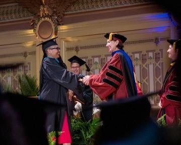 Graduating student shakes hand with Dean Slotterback