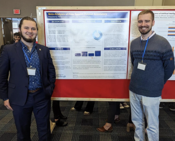 Two students present their research at a conference