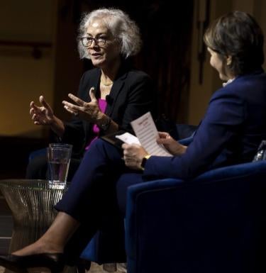 Marie Yovanovitch and Carissa Slotterback sit opposite each other on a stage, talking.